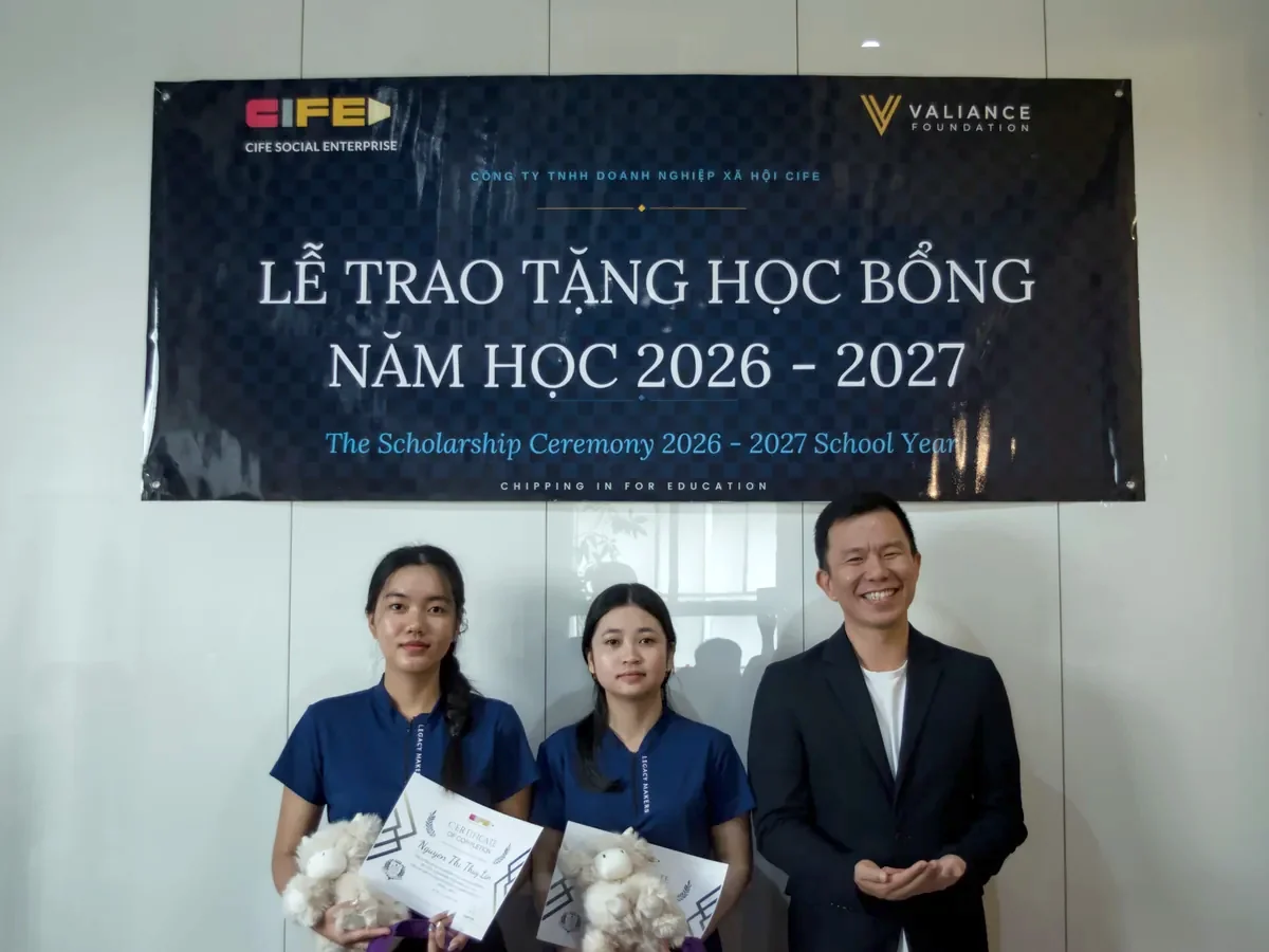 Two scholarship recipients with their certificates alongside a member of the awarding committee